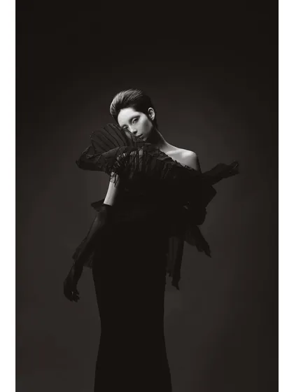 A black and white portrait of 'Athena'. This minimalist composition focuses on the sharp, angular lines of the styling and the model's striking features, creating a timeless and graphic image.