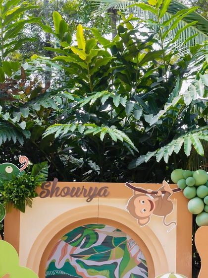 Close-up of the safari decor, showing a chameleon prop and a monkey hanging from a sign, adding playful details to the jungle theme.
