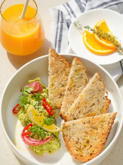 A true crowd-pleaser, our Smashed Chilli and Avocado Toast is breakfast perfection. We serve it on our house-made multigrain bread with a zesty topping of fresh avocado, red chilli, and lemon, paired with a glass of freshly squeezed orange juice.