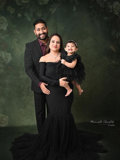 A joyful family of three. The baby's happy smile is the centerpiece of this lovely portrait, showcasing the happiness of her first birthday celebration.