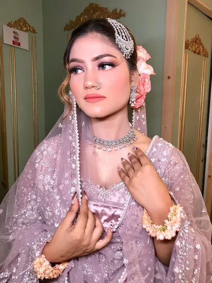 A full view of the client, her pastel lehenga and hair accessories creating a fairytale vibe.