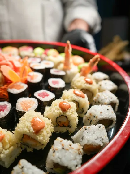 A glimpse of one of our large party platters being prepared by our chef. This spread includes a mix of tempura prawn rolls, classic tuna maki, and other house favorites, ready for a celebration.