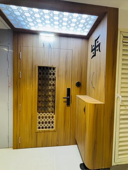 A wider view of the entrance, including the integrated shoe cabinet and the Swastik symbol for a traditional blessing.