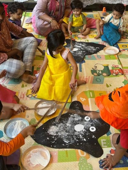 A ghostly art project for Halloween. The kids are using flour and glue to create messy ghost shapes on the floor, a perfect sensory activity for the occasion.