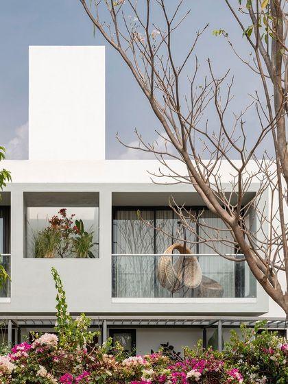 The upper-level balconies of the SAMAM House, featuring a mix of open and planter-box sections. This design adds a layer of greenery to the facade and provides private outdoor space for the bedrooms.