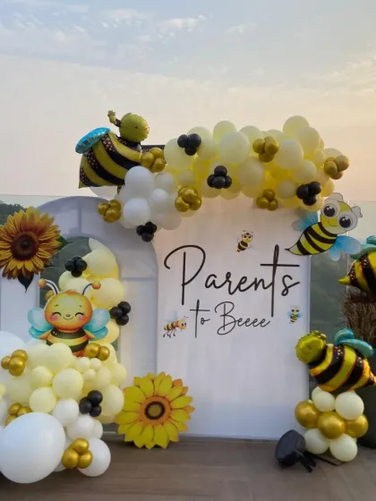 The perfect photo spot for the parents-to-bee. This custom backdrop with cute bee illustrations and a cheerful balloon garland was the centerpiece of a memorable baby shower.