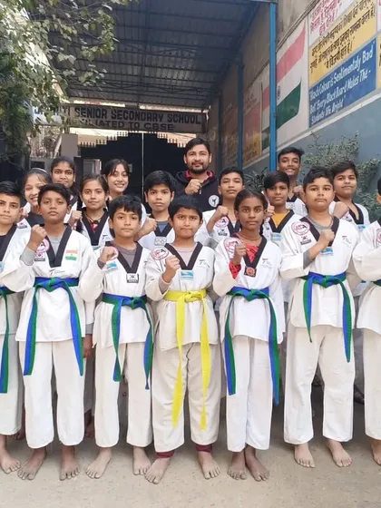 A group of our students proudly wearing their new blue and green belts after the color belt distribution ceremony.