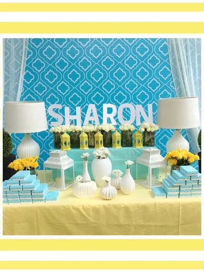The dessert and favor table for the Tuscan-themed luncheon. The blue and yellow color scheme was carried through in the backdrop and decor details for a cohesive look.