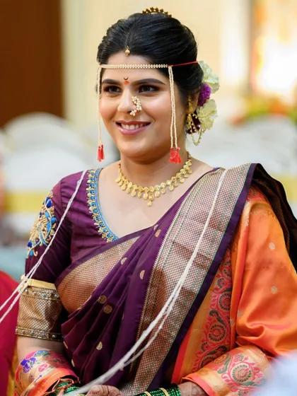 The bride during her wedding rituals, adorned with the traditional mundavalya. The makeup remains flawless and fresh throughout the long ceremony.
