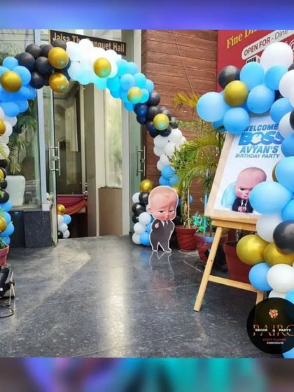 An entrance arch for a Boss Baby themed birthday party. The blue, black, and gold balloon arch and personalized welcome sign set the tone for the event right from the start.