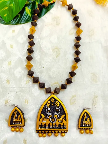 This elegant necklace features a horse motif, reminiscent of temple architecture. The combination of black and gold gives it a sophisticated and timeless appeal, perfect for pairing with silk sarees.