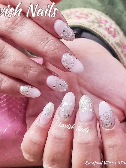 A beautiful set of almond-shaped nails with a scattered silver hexagonal glitter fade.