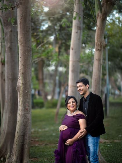 A happy, candid shot of the couple enjoying the beautiful natural surroundings during their garden maternity shoot.