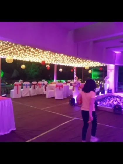 An outdoor evening event space with a ceiling covered in a dense net of fairy lights. This creates a starry night effect and provides beautiful ambient lighting for the entire guest area.
