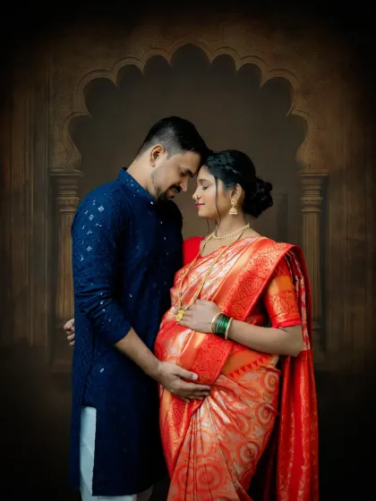 An intimate couple's portrait from a traditional maternity session. The focus is on their connection, with both partners embracing the baby bump, set against a classic arched backdrop.