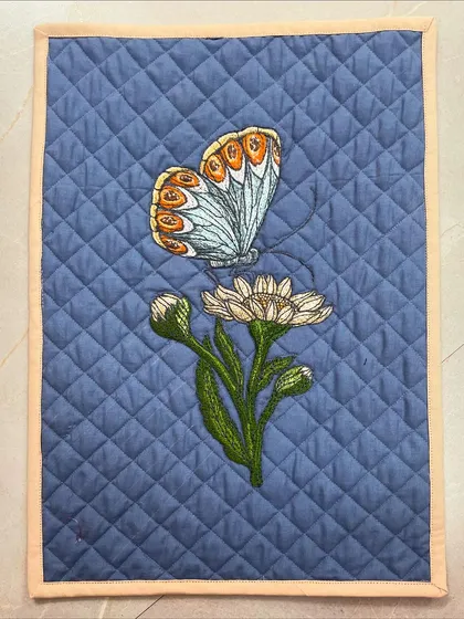 Another placemat from the same set, this one featuring a butterfly and a flower.