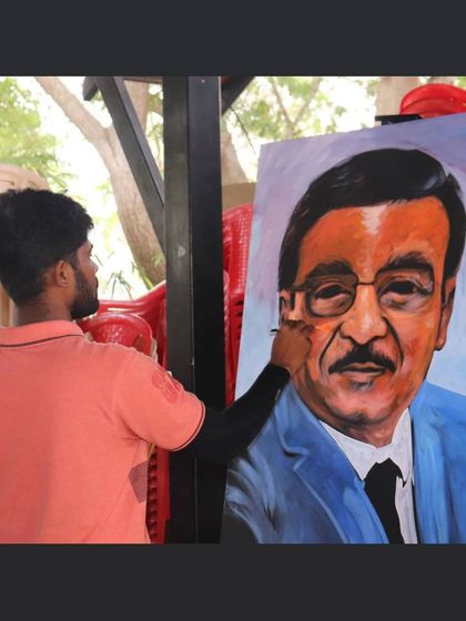 A close-up shot of me adding the final touches to a large-scale live portrait at an outdoor event.