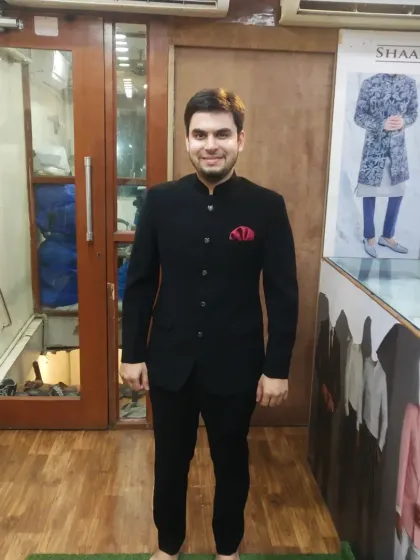 A client looking sharp in a classic black Jodhpuri suit at our Mumbai studio. This timeless, made-to-measure outfit is perfect for formal events, from weddings to receptions, and demonstrates our commitment to a flawless fit.