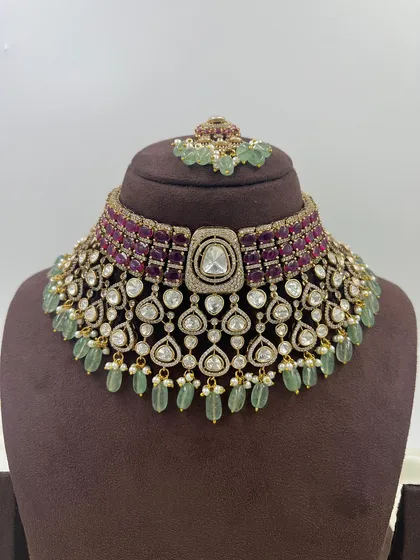 An exceptionally crafted bridal necklace set combining ruby-colored stones with mint-green bead drops. This piece demonstrates our ability to create complex, multi-colored designs with premium Moissanite stones for a rich, designer appeal.