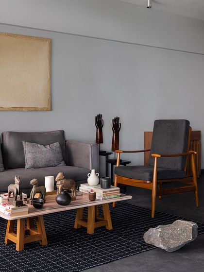 A comfortable grey sofa and armchair set the tone in this living room. I designed these pieces with a focus on timeless forms and durable materials, ensuring they remain stylish and functional for years.