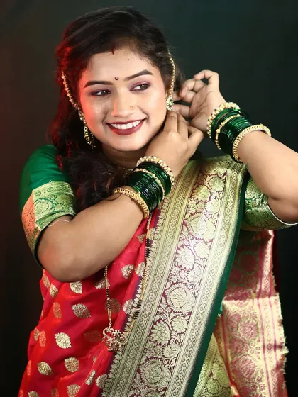 A classic pose showing the bride adjusting her earring. The makeup is designed to look beautiful from every angle.