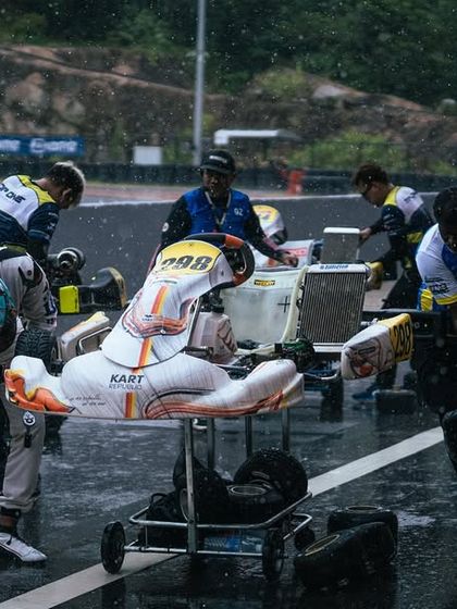 Our team rushes to make a setup change as the rain comes down, showcasing our ability to adapt to changing conditions.