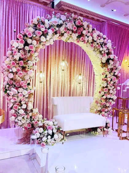 A perfect frame for your special moments. This full-circle floral arch, crafted with thousands of pink and white roses, serves as a stunning photo backdrop or an elegant stage for an engagement or reception.