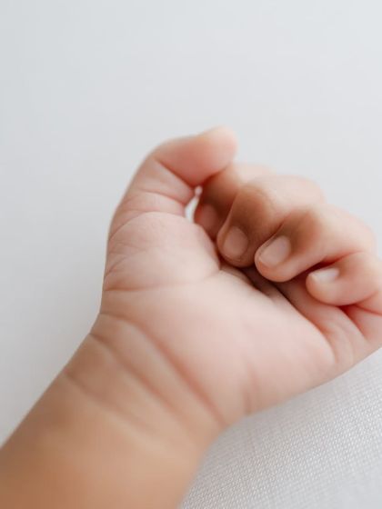 A newborn's tiny, curled fist. A simple, beautiful detail.