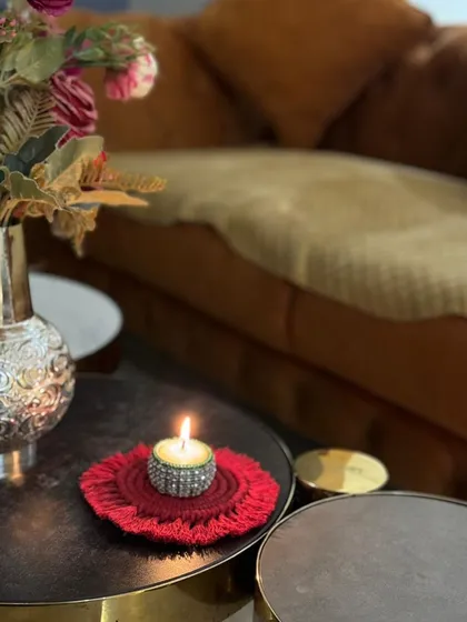 My handmade coasters are perfect for adding a small, detailed touch to your home. Here, one is being used as a base for a decorative candle, showing how versatile they are for protecting surfaces or just adding a bit of style to your coffee table. They make great housewarming gifts.