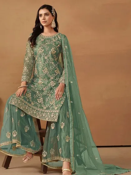 This teal-green net suit is so refreshing. The intricate sequence work and sharara style make it a trendy yet traditional choice for your next event.