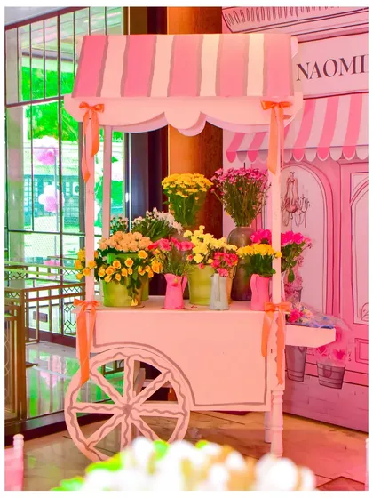 A lovely pink flower cart, filled with fresh blooms, added to the charm and elegance of the Parisian street theme.