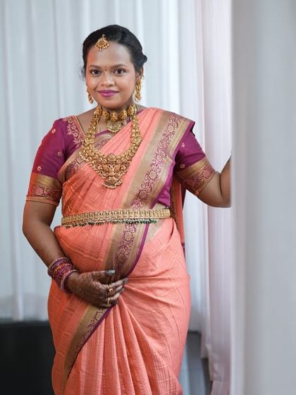 A beautiful portrait of our mom-to-be, Varsha. She is wearing a traditional temple choker, a long haram, and a matching vaddanam, creating a complete and graceful look.