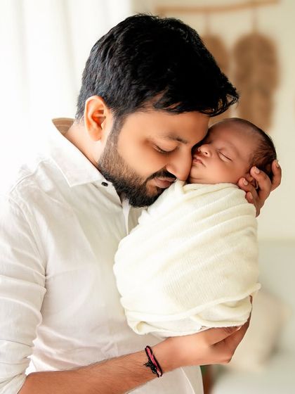 A tender moment between father and son. The soft lighting and close crop create an intimate and heartfelt portrait.