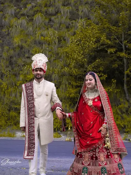 A romantic walk along a road, with the couple holding hands. This full-length shot showcases their beautiful wedding outfits against a natural, rustic background.