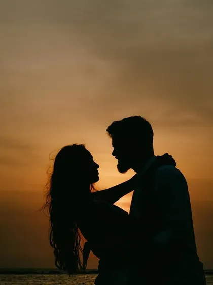 A classic sunset silhouette. The warm colors of the sky and the dark shapes of the couple create a timeless and romantic image that is always a favorite.