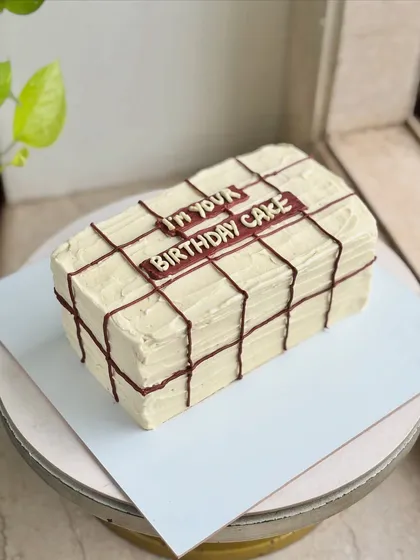 "I'm your birthday cake. Period." This witty cake is designed to look like a gift-wrapped present, a fun and minimal design for a birthday surprise.