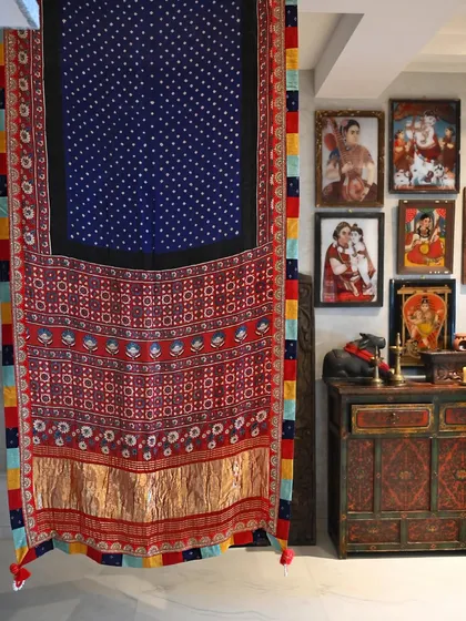 A saree is more than a garment; it is a canvas. Here, a hand-woven silk, dyed with traditional Bandhni and Ajrakh block-printing techniques, hangs as a testament to the artistry involved before it is even draped.