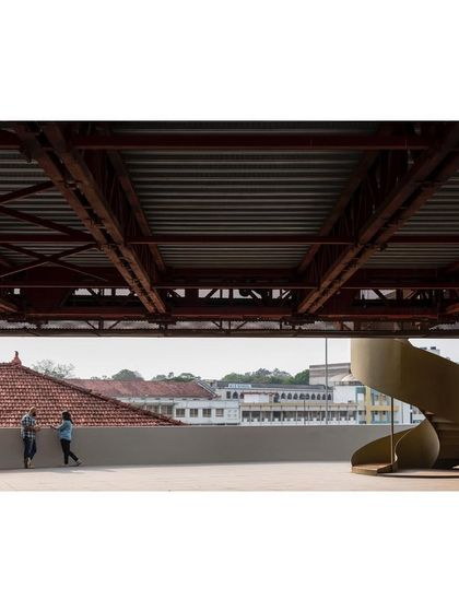 The terrace beneath "Hoverspace" acts as a pause point between the old and new structures, framing views of the surrounding campus and its older, tiled-roof buildings.