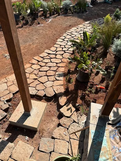 A view of the stone pathway being constructed. The path meanders through the garden, connecting the different parts of the house and encouraging exploration of the landscape.