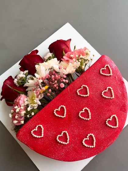 An overhead view of the red floral bouquet cake, showing the rich color and the intricate arrangement of flowers and pearl hearts.