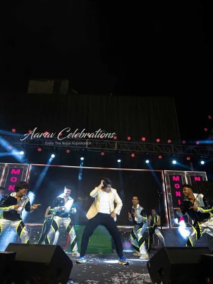 A wide shot of a family performance, capturing the energy of the dancer and his backup troupe under professional stage lighting. This showcases the concert-like quality of my sangeet productions.