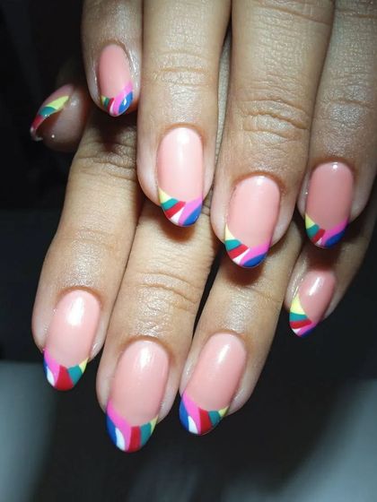 It’s the season of nude nails. These have a fun twist with colorful, geometric French tips.