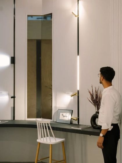 A visitor admiring our Space Walk 2 wall light at the exhibition. Our booths are designed as interactive galleries where you can experience the quality and effect of each fixture up close.