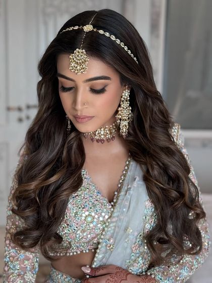 Elevated elegance with soft, flowing waves and a matha patti. A perfect bridal look for a pre-wedding function.