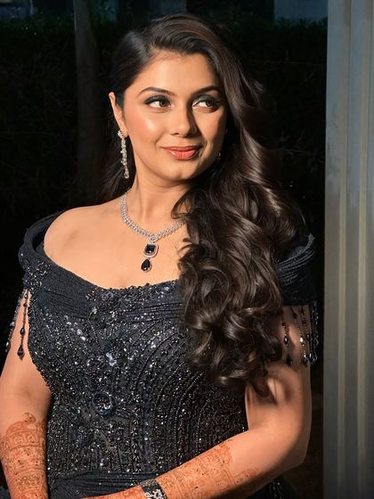 A side profile showcasing the beautiful soft curls and how the makeup enhances her features, creating a look of pure sophistication.