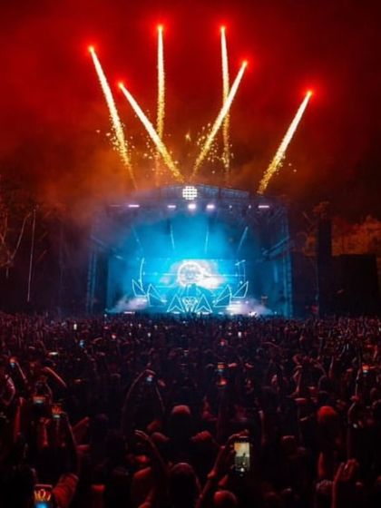 Fireworks erupt over the stage during Alan Walker's sold-out show in Kochi, lighting up the outdoor venue.