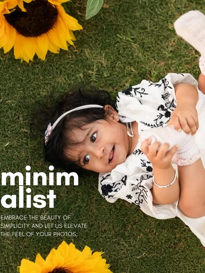 Embracing the beauty of simplicity. This little girl enjoys a moment lying on the grass surrounded by sunflowers, a perfect example of a minimalist and natural outdoor portrait.
