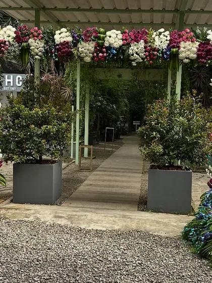 A duplicate image showing the stunning wedding entrance we designed. The decor features a large floral arch and a custom-made peacock sculpture, meticulously crafted from flowers.