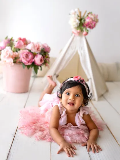 This little girl in her pink tutu is enjoying her floral teepee setup. It's a perfect theme for a girly and sweet sitter session.