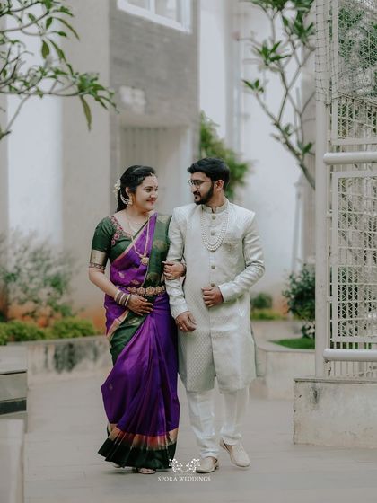 The couple walking arm-in-arm, sharing a smile, perfectly coordinated in their traditional attire.